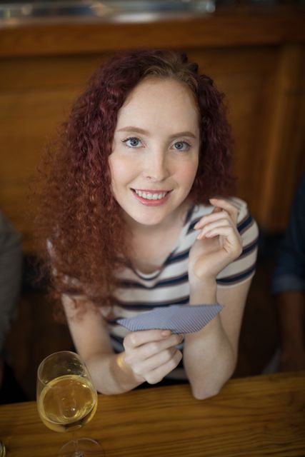 Beautiful woman holding cards in bar - Download Free Stock Photos Pikwizard.com