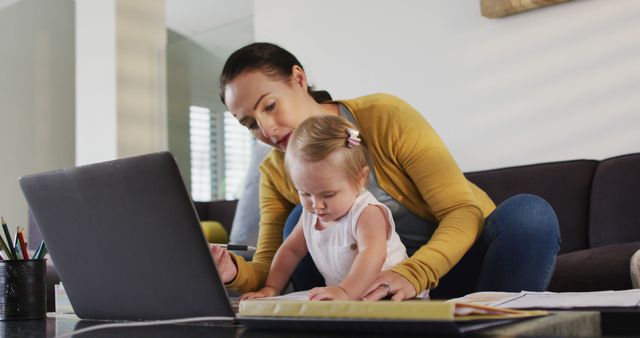 Caucasian mother holding her baby taking notes while working from home. motherhood, love and childcare concept