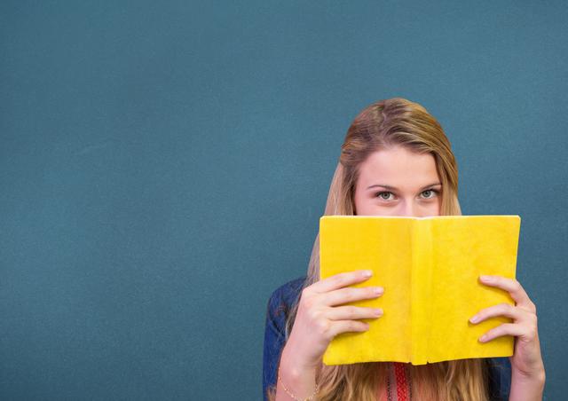 Woman holding a book in front of her face - Download Free Stock Photos Pikwizard.com