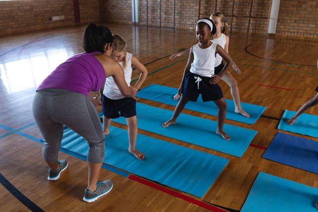 Female yoga teacher teaching yoga to school kids in school - Download Free Stock Photos Pikwizard.com
