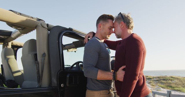 Happy caucasian gay male couple standing by car embracing on sunny day at the beach - Download Free Stock Photos Pikwizard.com