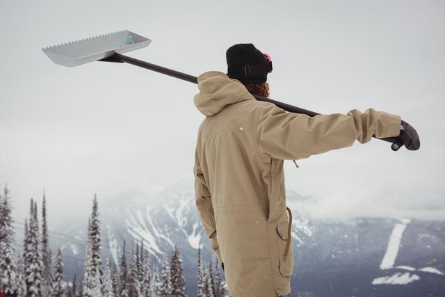 Man holding snow shovel in ski resort - Download Free Stock Photos Pikwizard.com