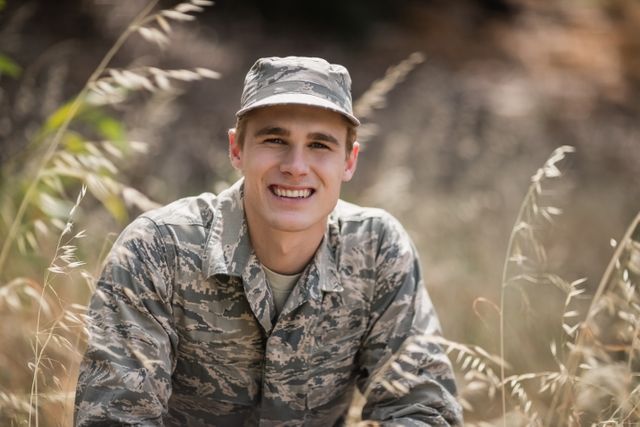 Portrait of happy military soldier crouching in grass - Download Free Stock Photos Pikwizard.com