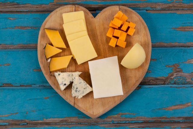 Variety of cheese on heart shaped chopping board - Download Free Stock Photos Pikwizard.com