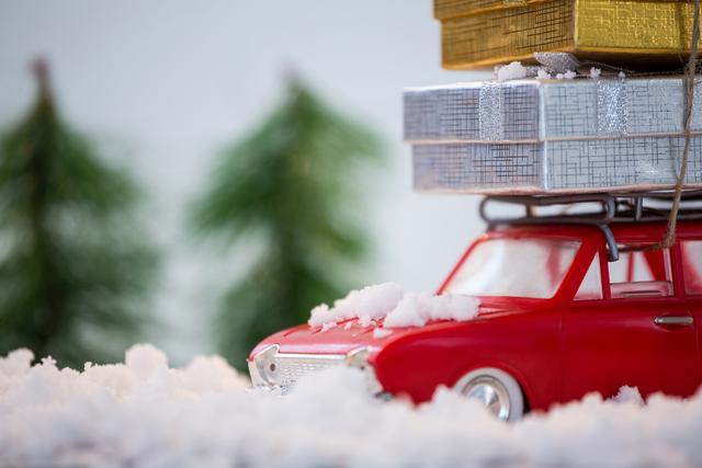 Toy car carrying christmas present on fake snow - Download Free Stock Photos Pikwizard.com