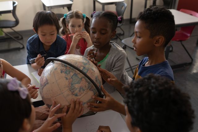 Group of kids studying a globe together in classroom - Download Free Stock Photos Pikwizard.com