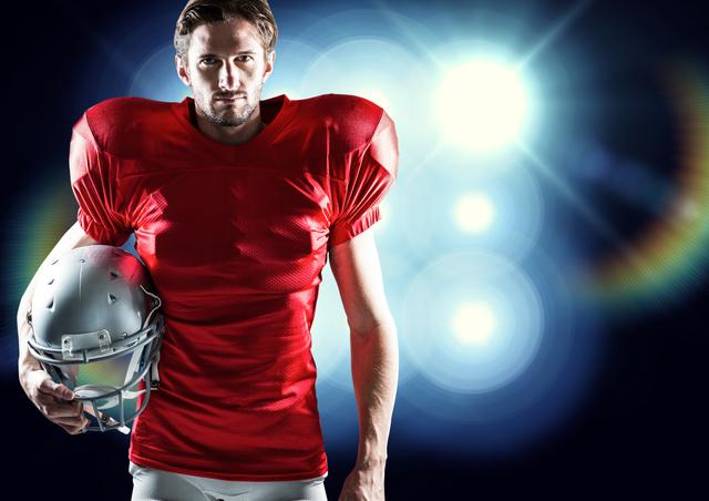 American football player holding helmet against illuminated blue background - Download Free Stock Photos Pikwizard.com