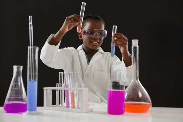 Schoolgirl doing a chemical experiment against black background - Download Free Stock Photos Pikwizard.com