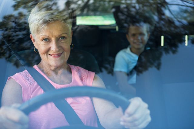 Grandmother driving a car while grandson sitting in the back seat - Download Free Stock Photos Pikwizard.com