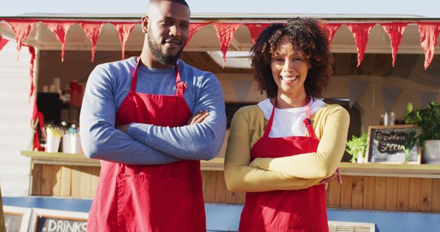 Portrait of african american couple with arms crossed smiling while standing near the food truck. food truck and street food concept