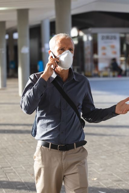 Senior man wearing face mask talking on smartphone - Download Free Stock Photos Pikwizard.com
