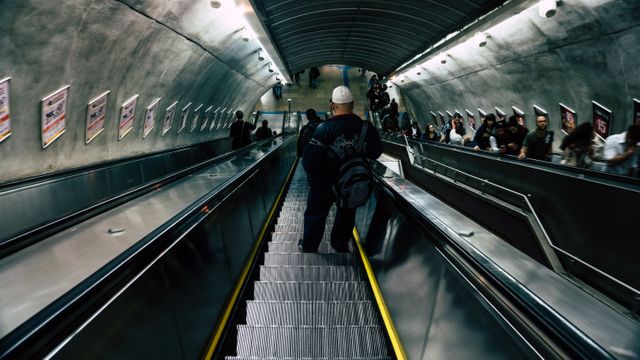 Man in Black Leather Jacket on Escalator - Download Free Stock Photos Pikwizard.com
