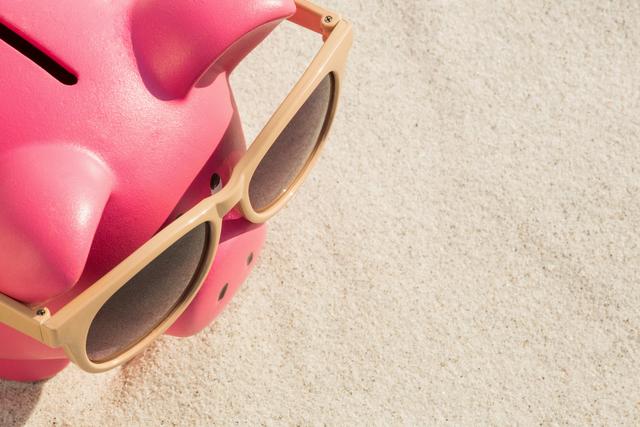 Close-up of piggy bank with sunglasses kept on sand - Download Free Stock Photos Pikwizard.com