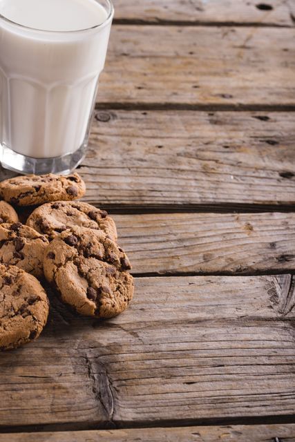 Cookies by glass of milk on wooden table with copy space - Download Free Stock Photos Pikwizard.com