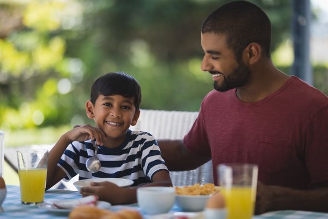 Portrait of boy with father having breakfast at table - Download Free Stock Photos Pikwizard.com