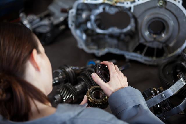 Female mechanic fixing gear - Download Free Stock Photos Pikwizard.com