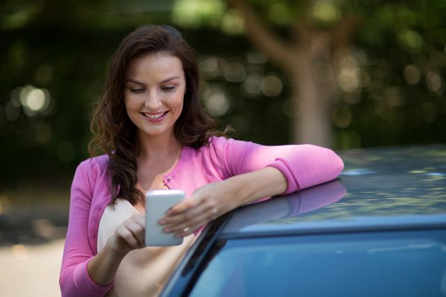 Woman using mobile phone while standing by car - Download Free Stock Photos Pikwizard.com
