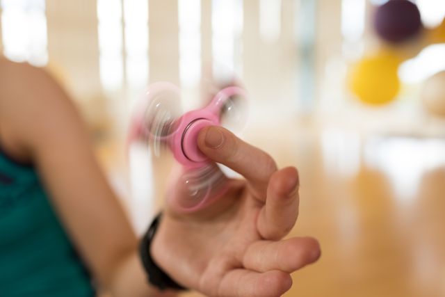 Girl playing with fidget spinner- Download Free Stock Photos Pikwizard.com