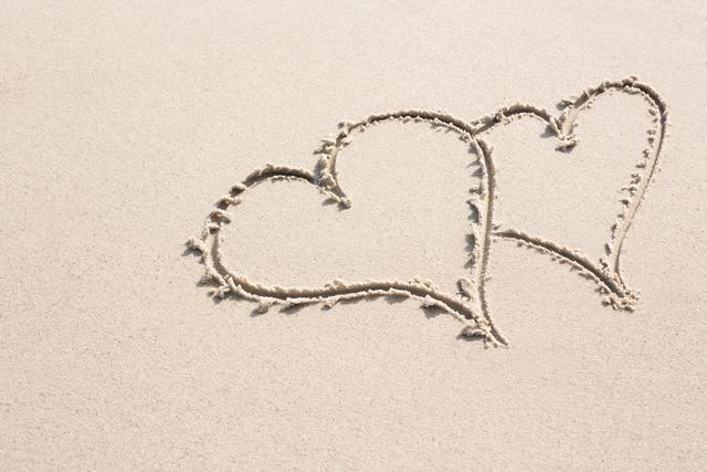 Two heart shapes drawn on sand - Download Free Stock Photos Pikwizard.com