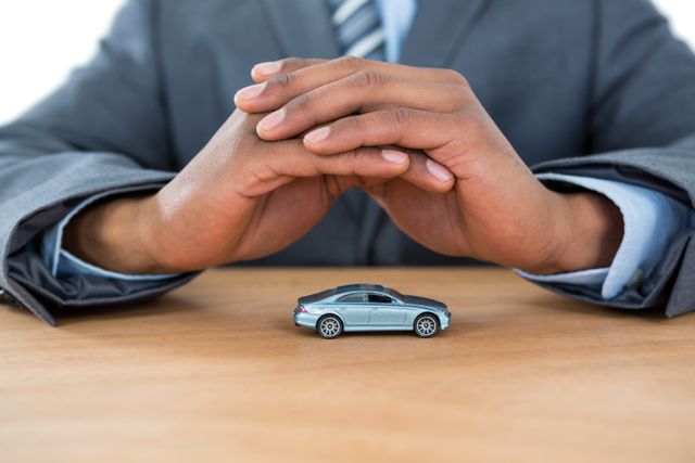 Businessman protecting toy car with hands - Download Free Stock Photos Pikwizard.com
