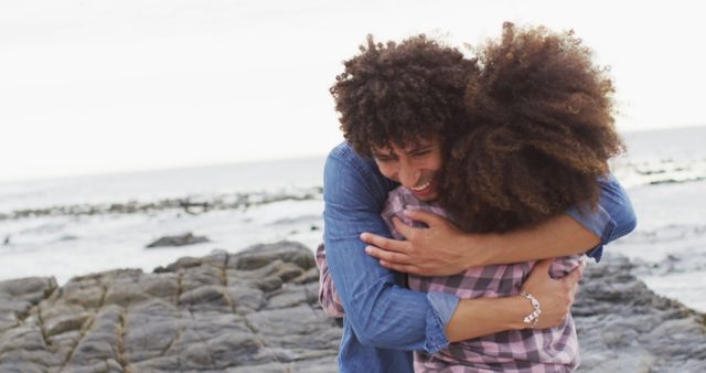 African american couple hugging each other on the rocks near the sea - Download Free Stock Photos Pikwizard.com