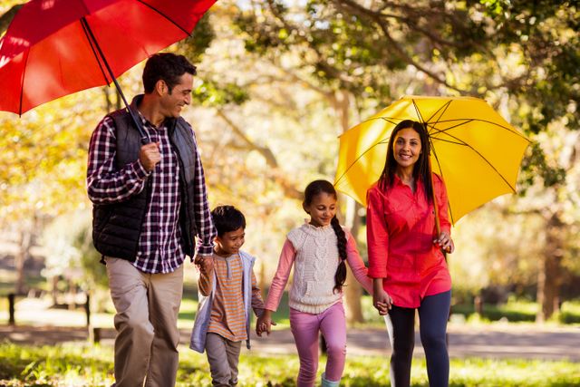 Happy family walking with umbrellas - Download Free Stock Photos Pikwizard.com