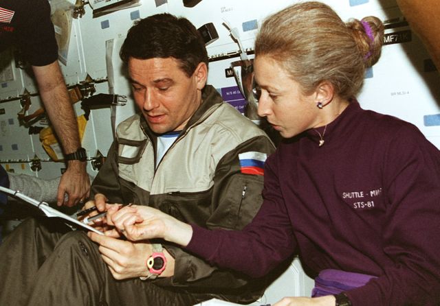 STS081-357-020 (12-22 Jan. 1997) --- Astronaut Marsha S. Ivins, STS-81 mission specialist, compares notes with cosmonaut Valeri G. Korzun, Mir-22 mission commander. The two were involved with the transfer of supplies from the Space Shuttle Atlantis to Russia's Mir Space Station, during the docking mission.