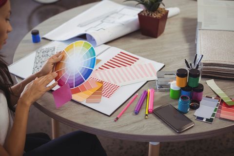 Businesswoman holding colour swatch at office desk - Download Free Stock Photos Pikwizard.com