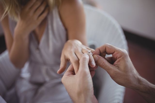 Man putting engagement ring on womans hand - Download Free Stock Photos Pikwizard.com