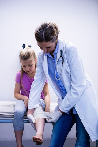 Doctor putting bandage on injured leg of patient - Download Free Stock Photos Pikwizard.com