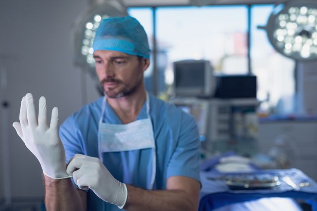 Male surgeon wearing surgical gloves in operation room - Download Free Stock Photos Pikwizard.com