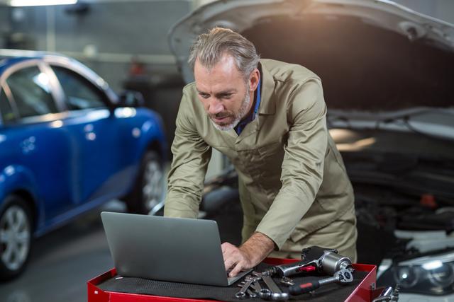 Mechanic using laptop in repair garage