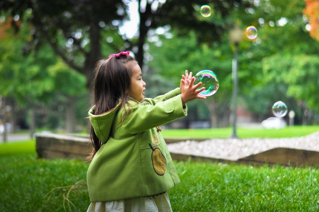 a little girl playing with soap bubbles - Download Free Stock Photos Pikwizard.com