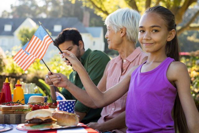 Girl holding american flag near the picnic table - Download Free Stock Photos Pikwizard.com