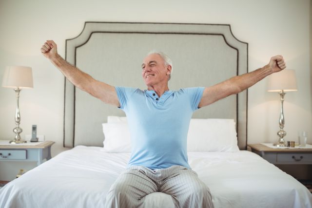 Senior man stretching arms on bed - Download Free Stock Photos Pikwizard.com