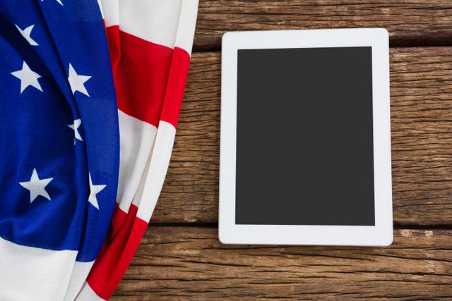 Close-up of American flag and digital tablet arranged on wooden table