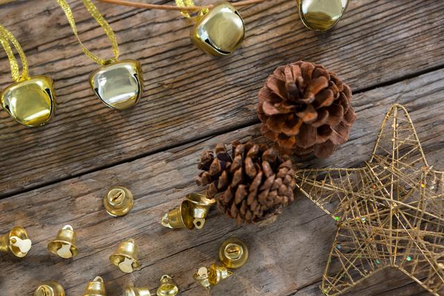 Christmas bells, pine cone and star on wooden plank - Download Free Stock Photos Pikwizard.com