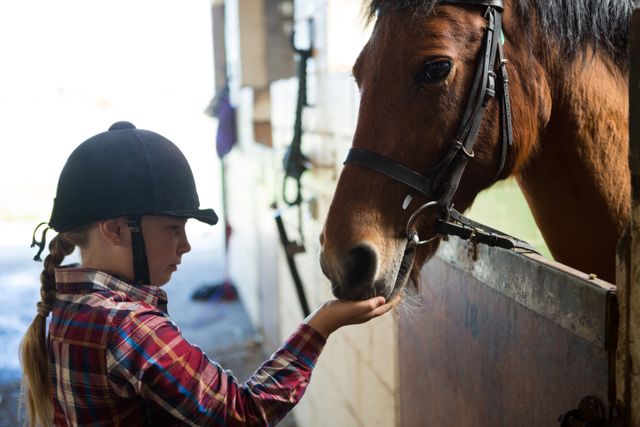 Girl feeding the horse in the stable - Download Free Stock Photos Pikwizard.com