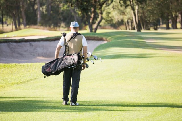 Rear view of sportsman walking with his golf bag - Download Free Stock Photos Pikwizard.com