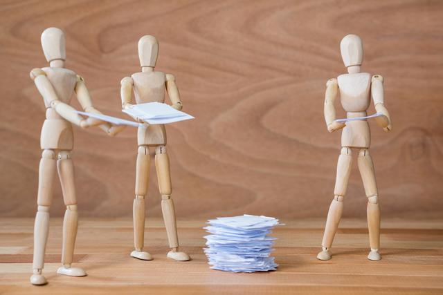 Conceptual image of figurine standing around stack of paper