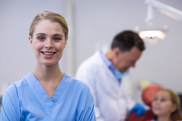 Smiling dental assistant standing in dental clinic - Download Free Stock Photos Pikwizard.com