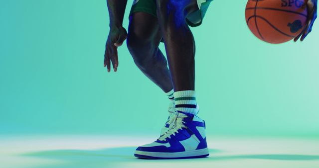 Image of low section of african american male basketball player bouncing ball on blue background - Download Free Stock Photos Pikwizard.com