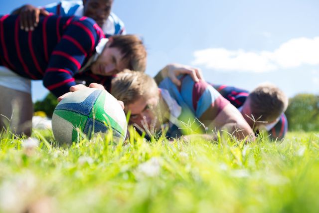 Close up of men playing rugby while lying at grassy field - Download Free Stock Photos Pikwizard.com