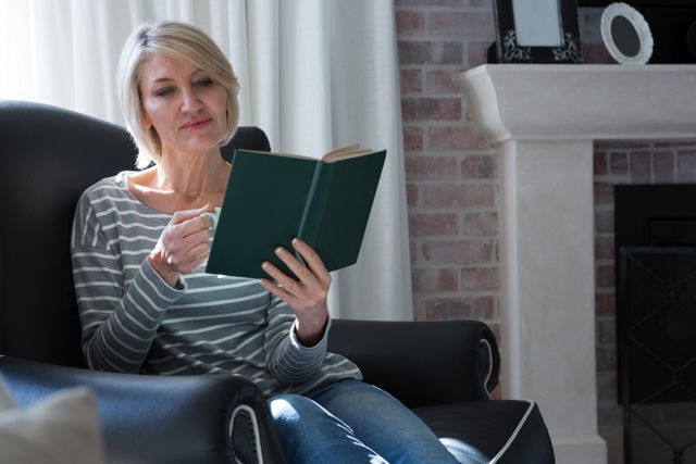 Beautiful woman reading book while having coffee - Download Free Stock Photos Pikwizard.com