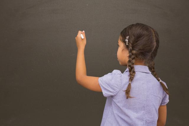School girl writing on blackboard - Download Free Stock Photos Pikwizard.com
