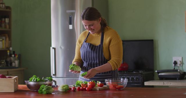 Happy caucasian woman preparing salad, chopping vegetables in kitchen. homesteading, healthy lifestyle on organic farm in the countryside.