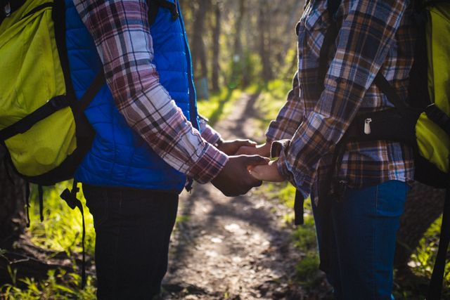 Mid section of couple holding hands while trekking in the forest - Download Free Stock Photos Pikwizard.com