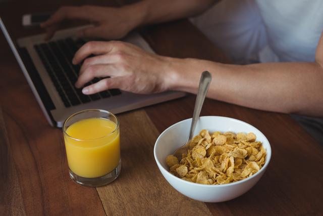 Mid section of man using laptop while having breakfast in bedroom - Download Free Stock Photos Pikwizard.com