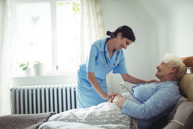Nurse interacting with senior woman on bed - Download Free Stock Photos Pikwizard.com