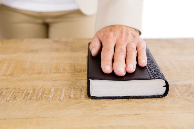 Midsection of woman with hand on bible - Download Free Stock Photos Pikwizard.com